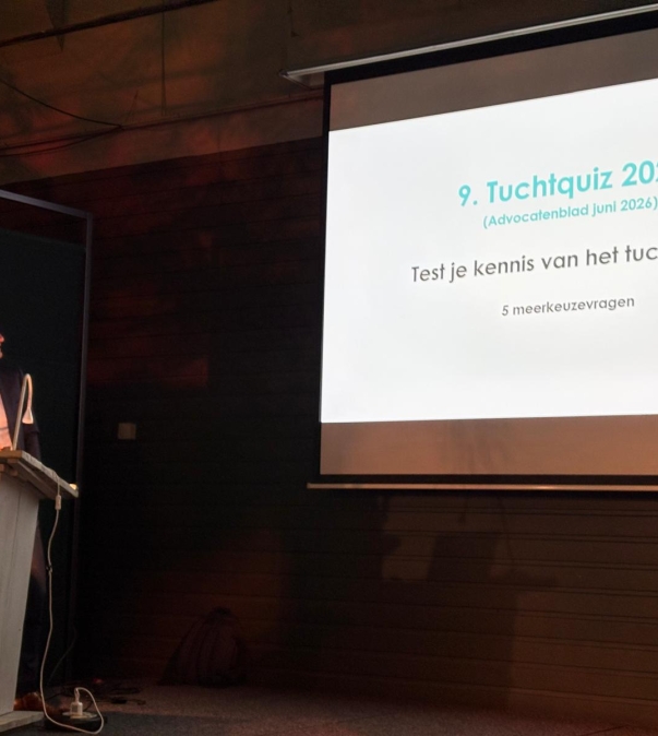 Foto van Joris Luijten met de achtergrond een presentie met de tekst "Tuchtquiz 2026"